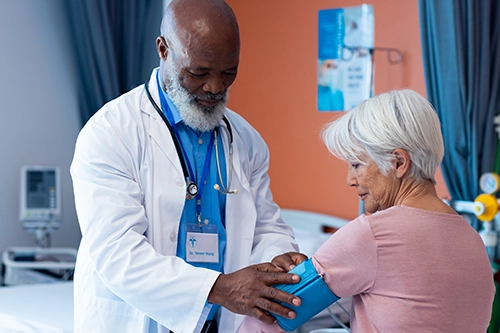 doctor takes blood pressure of a senior lady patient with white hair